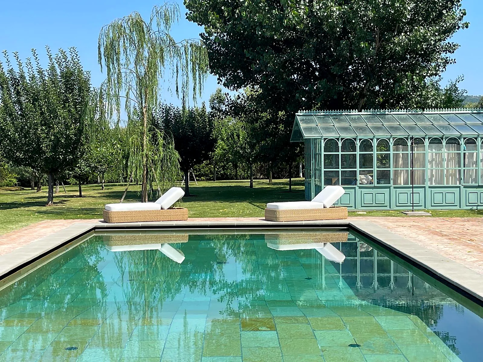 Piscina rinnovata con rivestimento in pietra verde nel giardino